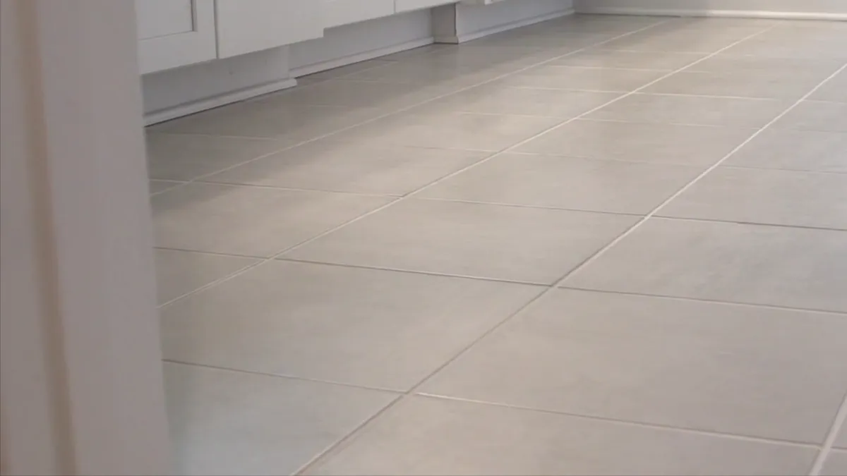 Large-format tile running to the baseboard in a new kitchen